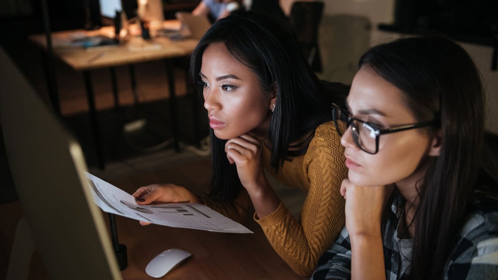 Zwei Frauen schauen auf ihre Datensätze von Google Analytics.