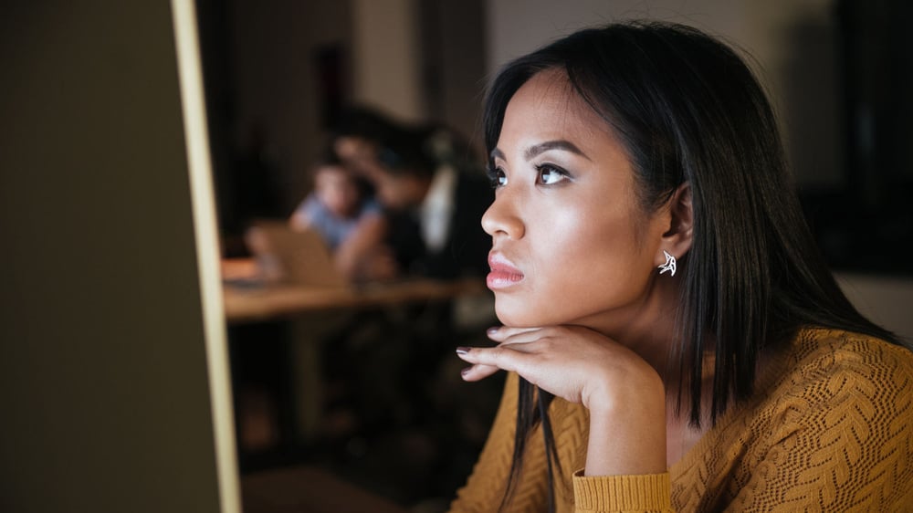 Eine Frau guckt konzentriert auf ihre Google Analytics Daten von ihrer Website auf dem Computer.