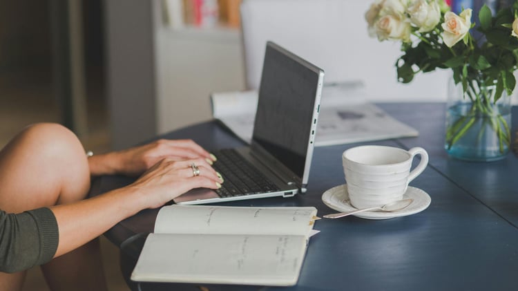 Frau sitzt zu Hause am Schreibtisch und nimmt an einem Semrush Training teil.